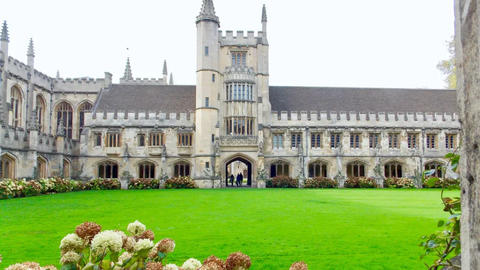 University of Cambridge building with green lawn in foreground.