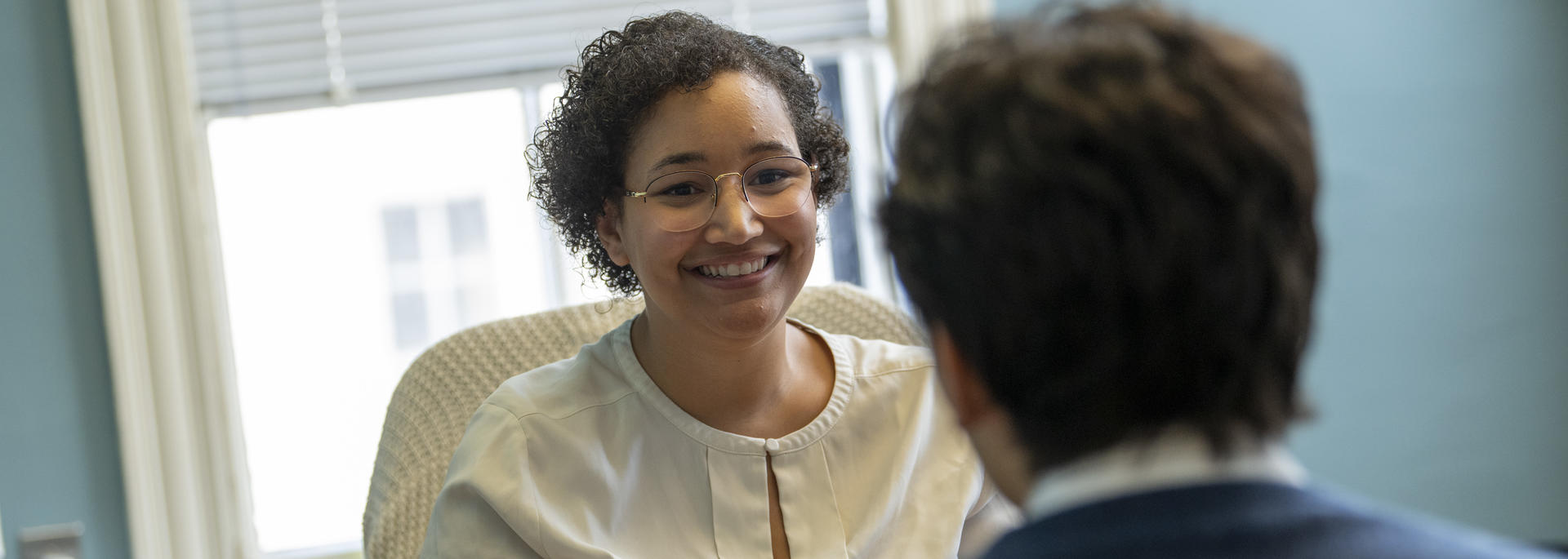 A smiling URAF staff member advises a student.